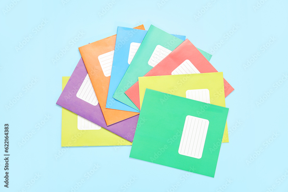 Different colorful notebooks on blue background