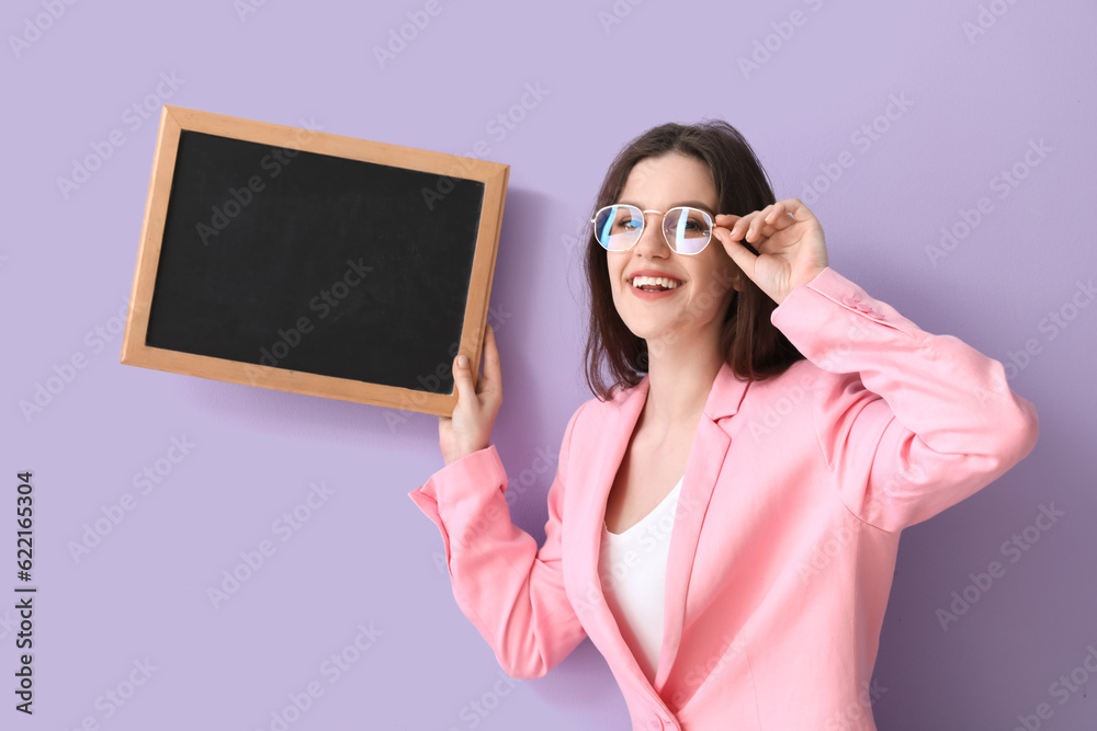 Female teacher with chalkboard on lilac background