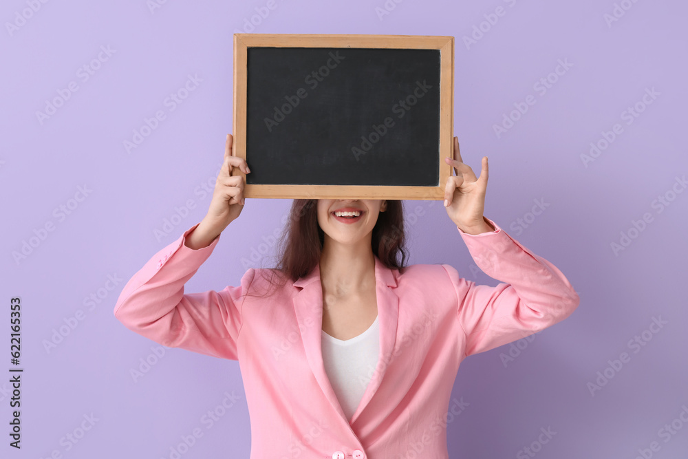 Female teacher with chalkboard on lilac background