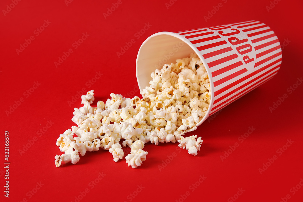 Bucket with tasty popcorn on red background