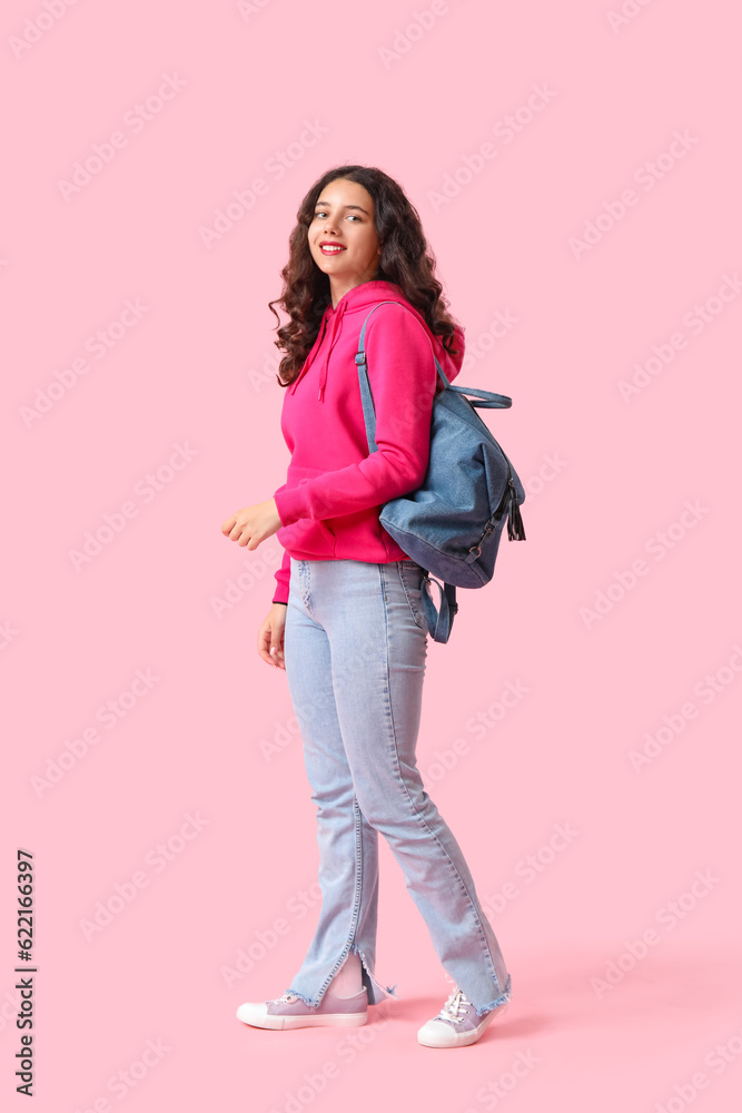 Female student with backpack on pink background