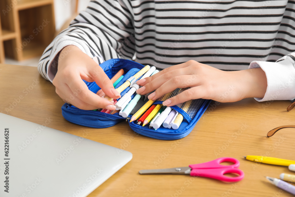 Female student with pencil case at table, closeup