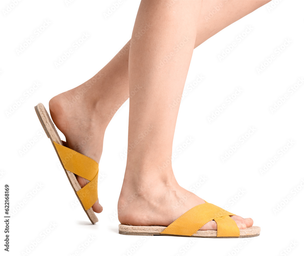 Female legs in flip-flops on white background