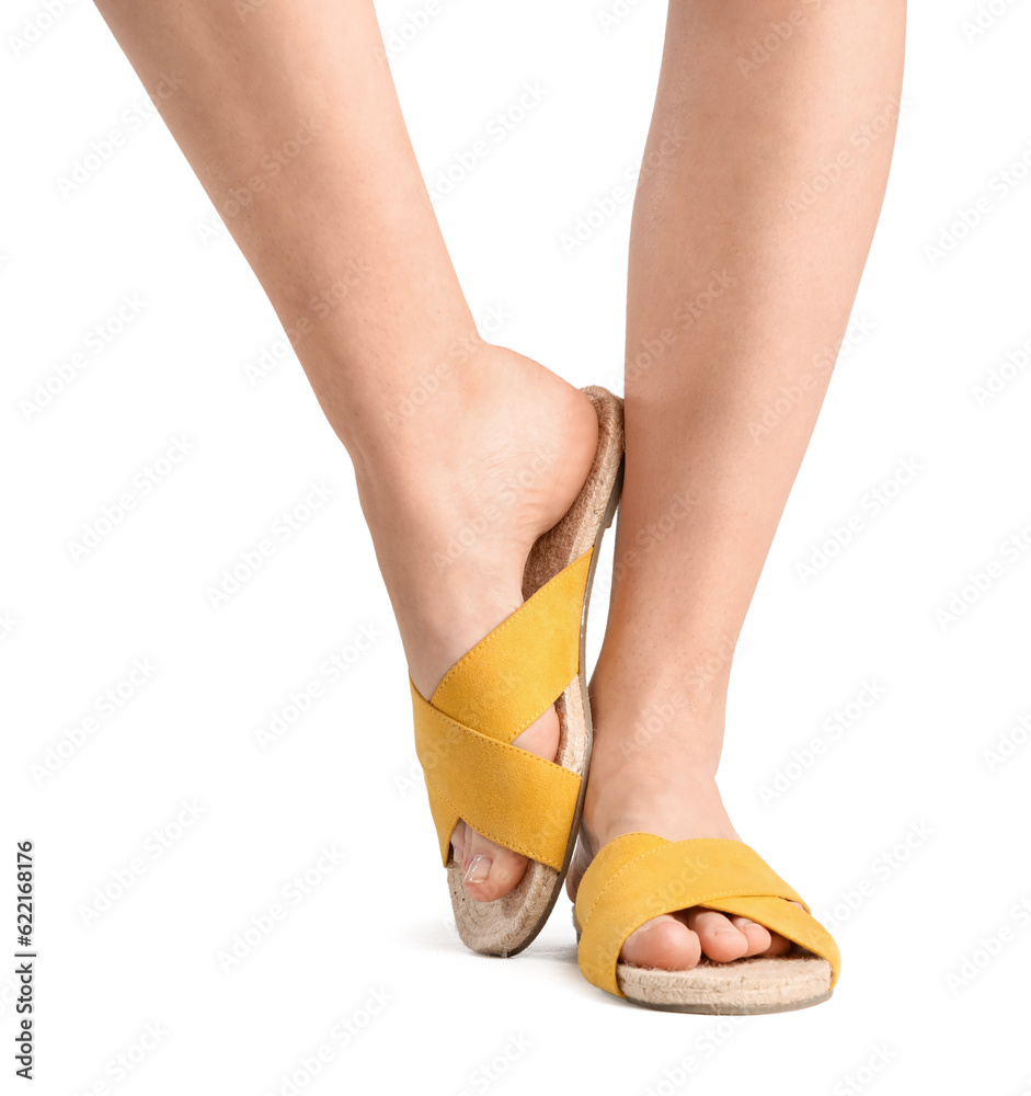 Female legs in flip-flops on white background