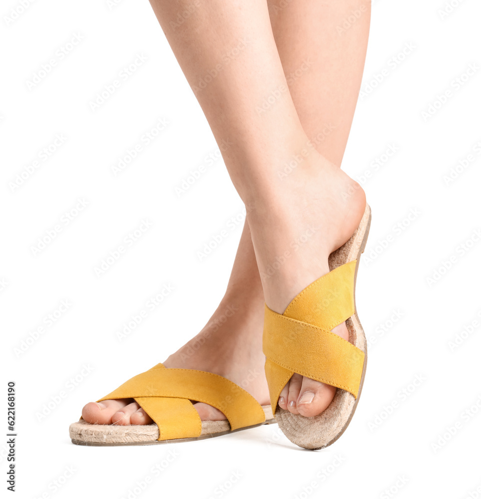 Female legs in flip-flops on white background