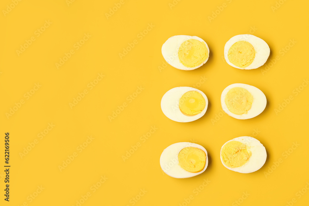 Halves of tasty boiled eggs on yellow background