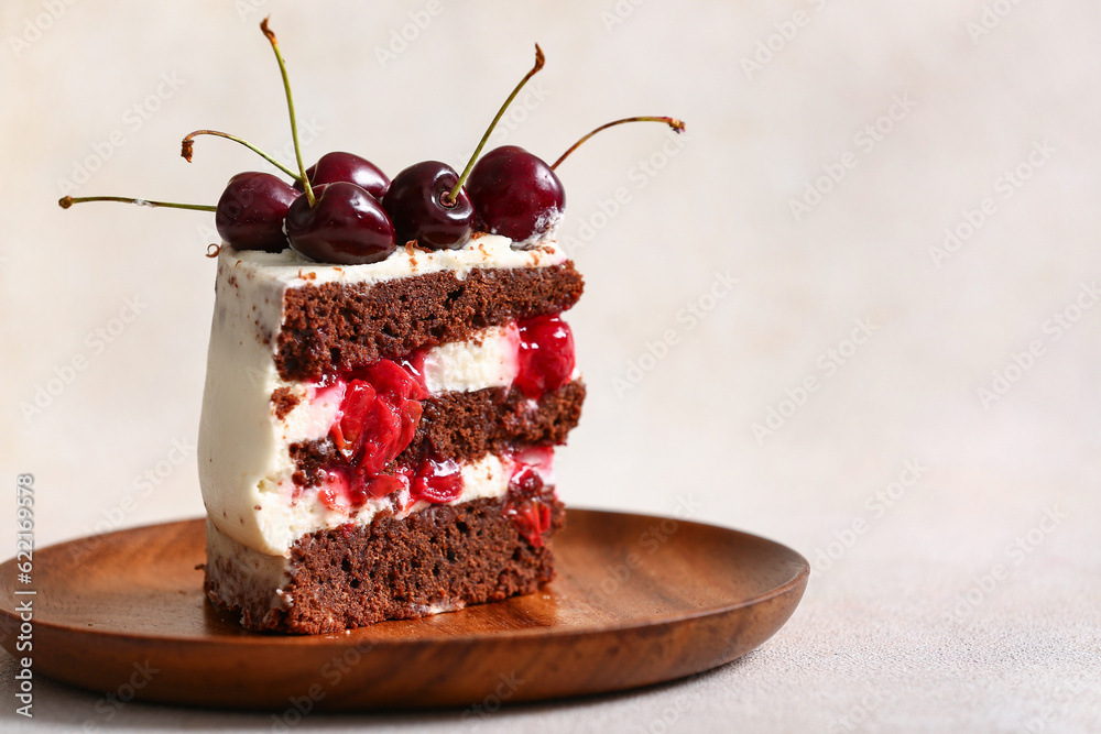 Plate with piece of tasty cherry cake on light background