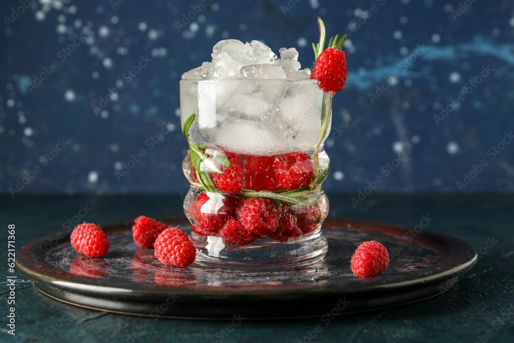 Glass of fresh raspberry lemonade with rosemary on dark table