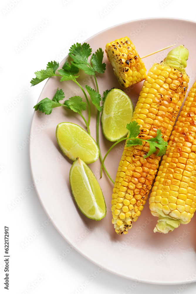 Plate with tasty grilled corn cobs and lime on white background