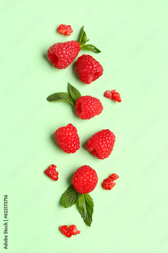 Fresh raspberries and mint on green background