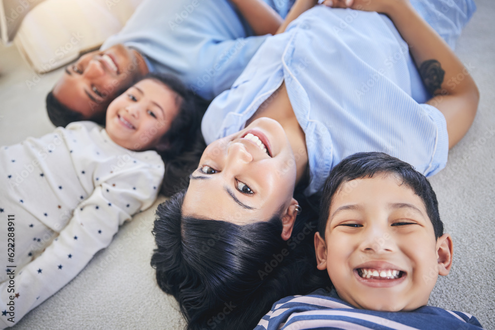 Top view, portrait and happy family on a floor relax, bond and playing in their home on the weekend.