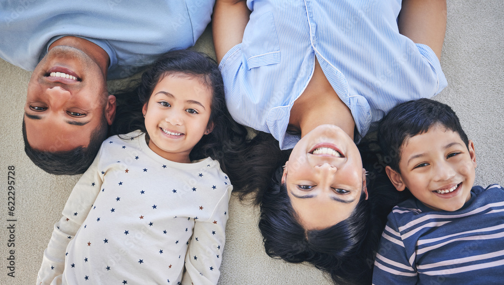 Above, portrait and happy family on a floor relax, bond and playing in their home on the weekend. Fa