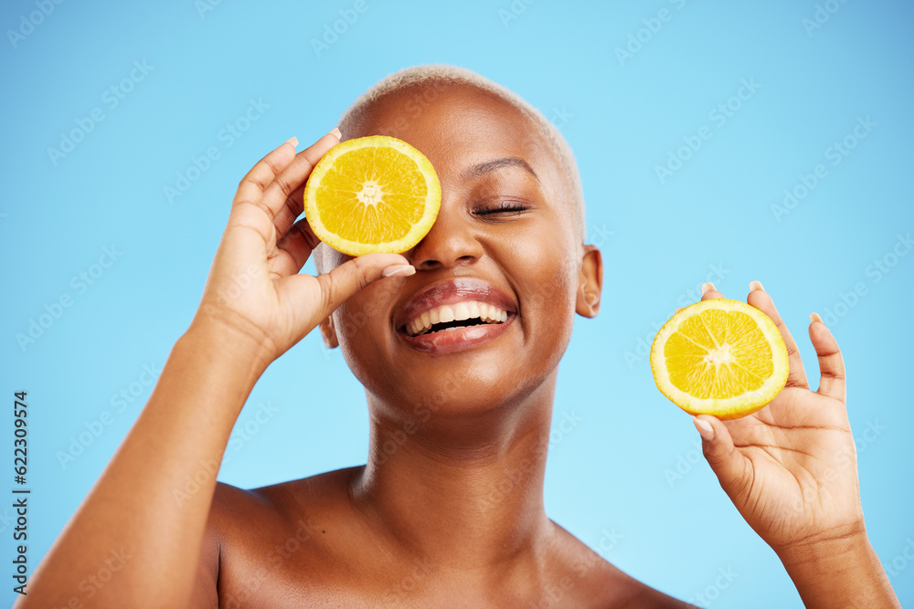 Skincare, orange and smile with a model black woman in studio on blue background for treatment. Face