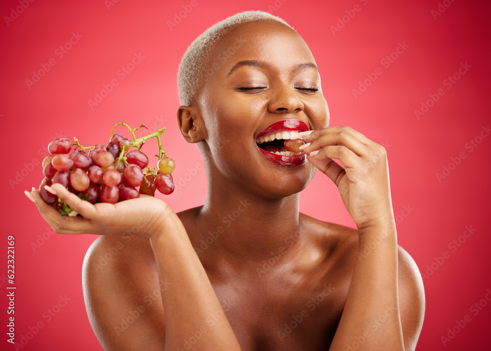 Health, eating and a black woman with grapes on a red background for nutrition or diet. Smile, beaut