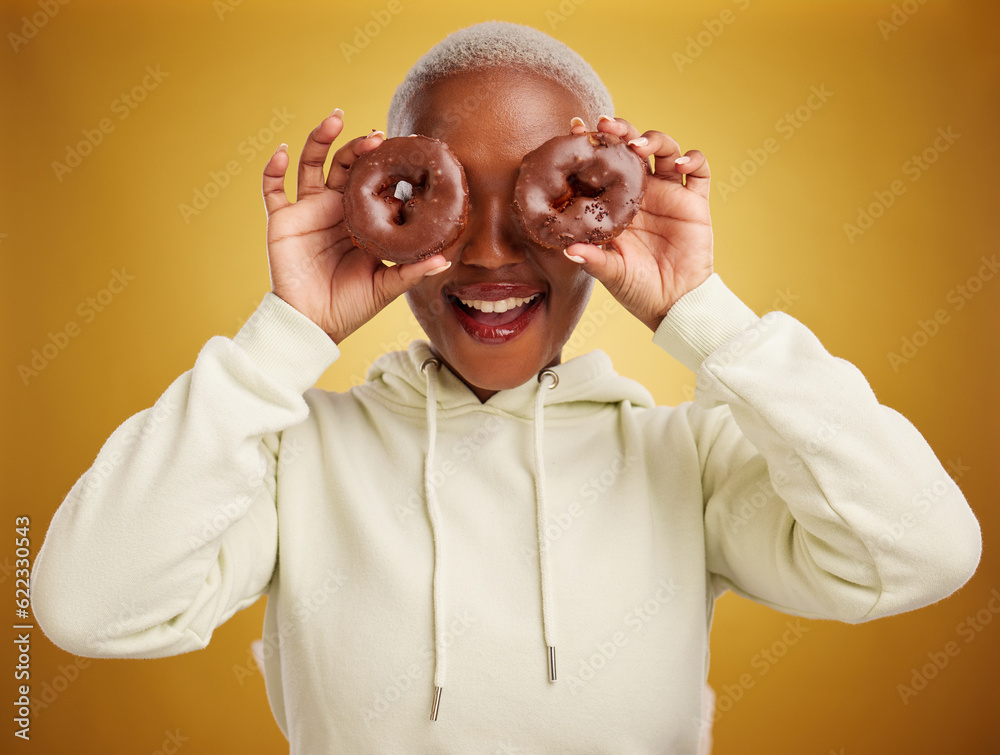 Face, chocolate and donut with a black woman in studio on a gold background for candy or unhealthy e