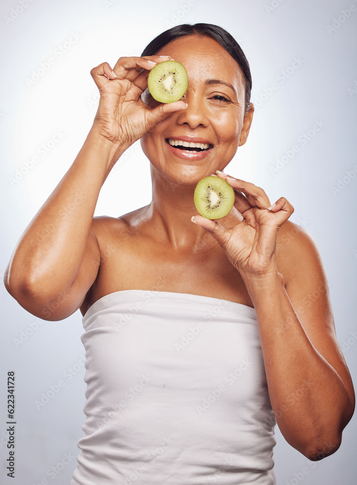 Skincare, portrait and senior woman with kiwi in studio isolated on a white background. Food, natura