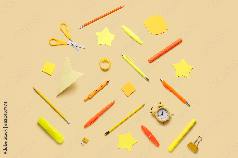 Composition with colorful stationery and alarm clock on color background