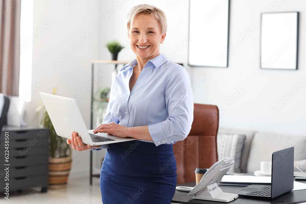 Mature businesswoman with laptop  in office