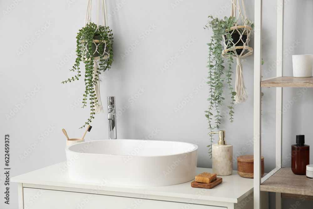 White sink with bath accessories on table in room