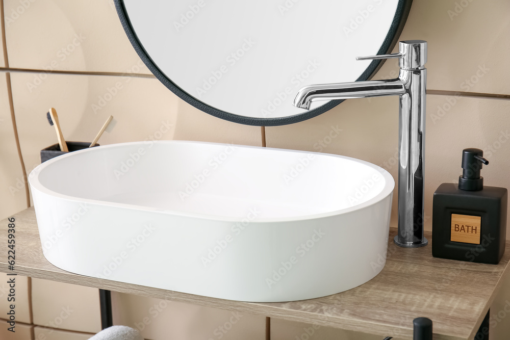 White sink with soap on shelf in bathroom