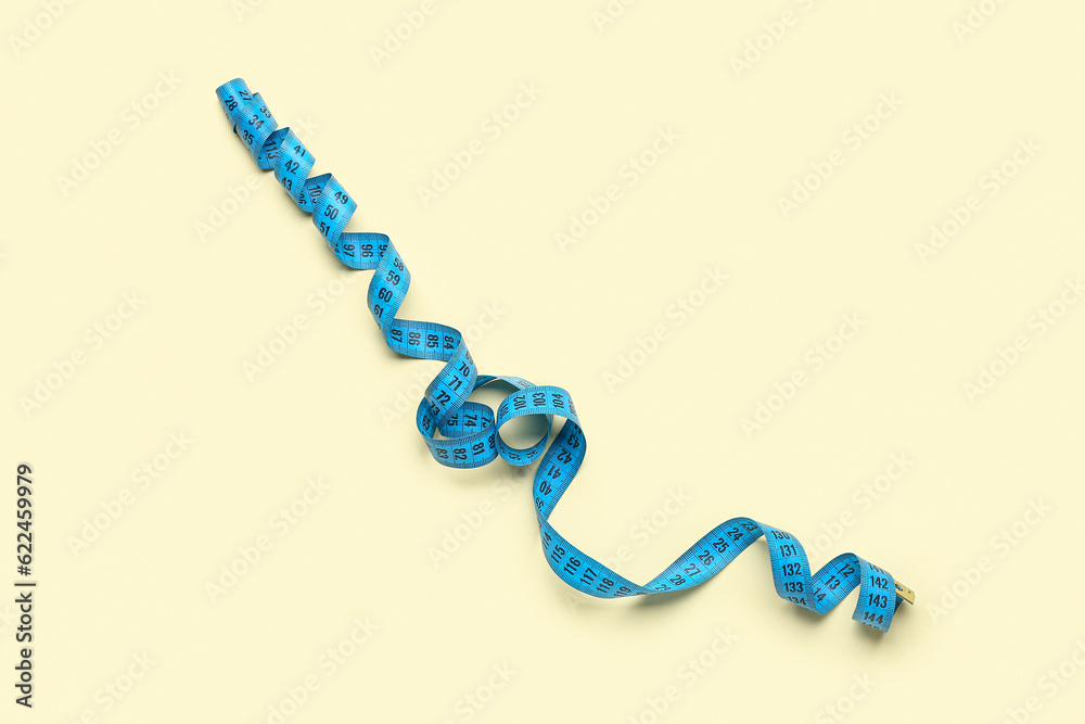 Blue measuring tape on beige background