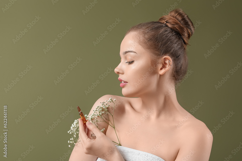 Beautiful young woman with ampule and flowers on color background. Skin care concept