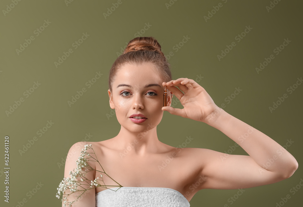 Beautiful young woman with ampule and flowers on color background. Skin care concept