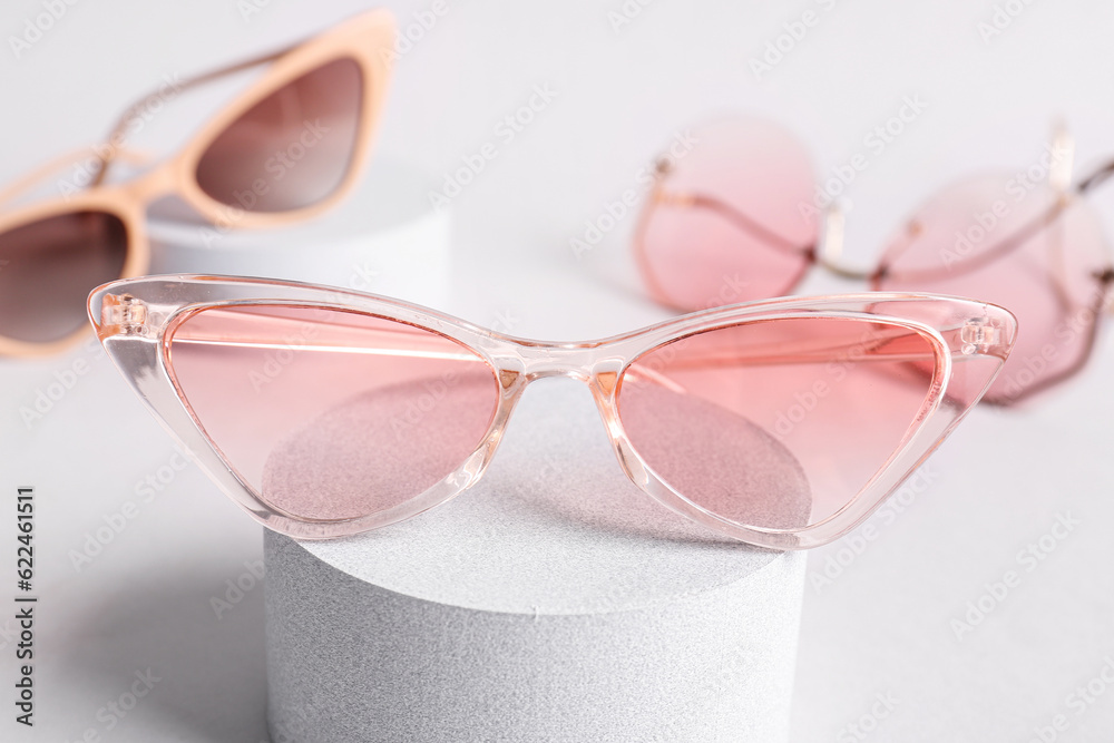 Stand with stylish eyeglasses on white background, closeup