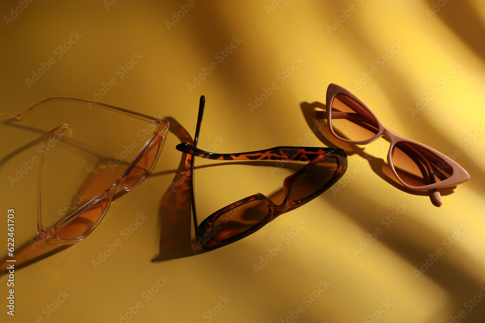 Stylish eyeglasses on yellow background