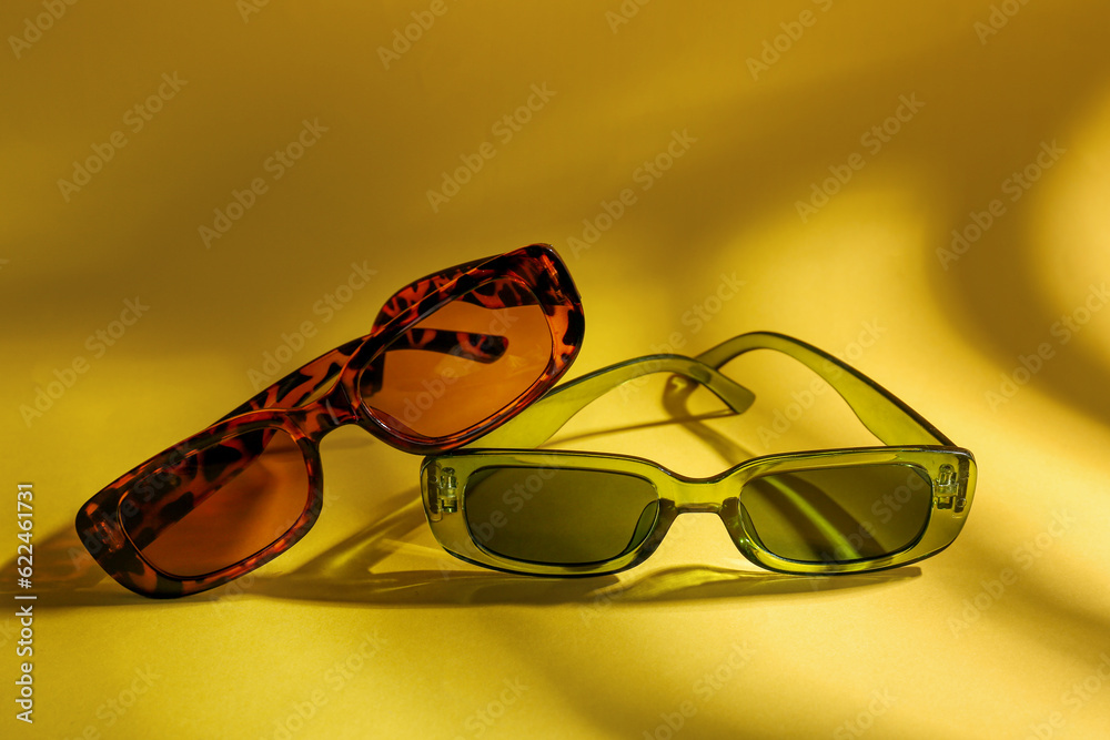 Stylish eyeglasses on yellow background