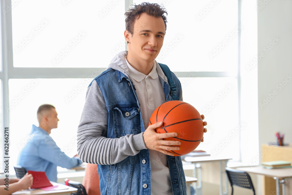 Male student with ball in classroom