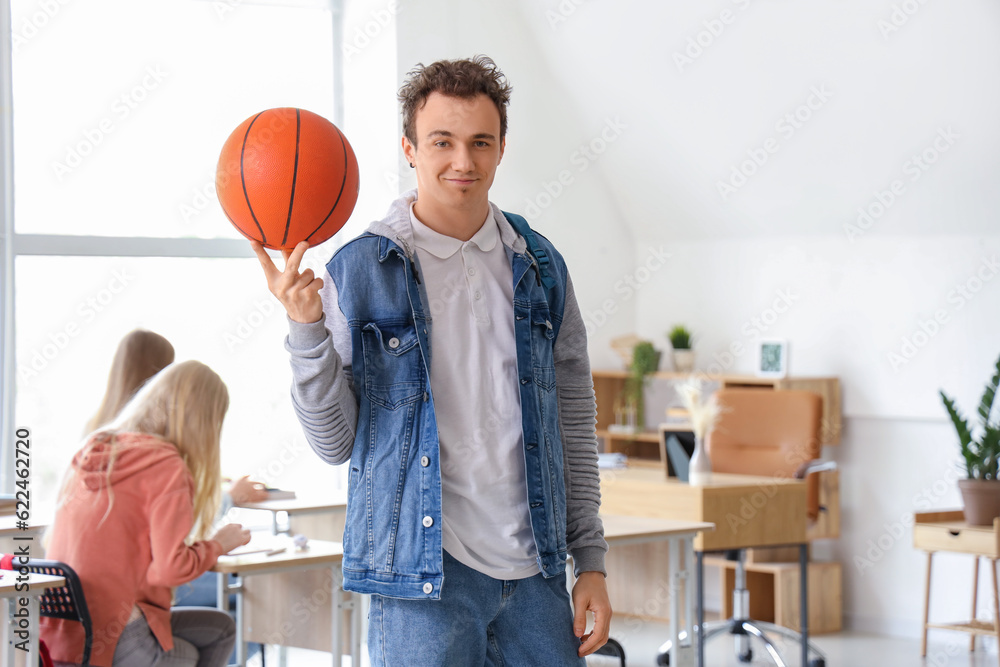 Male student with ball in classroom