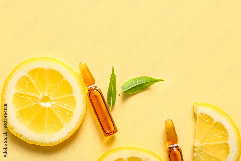 Ampoules with vitamin C and lemon slices on yellow background