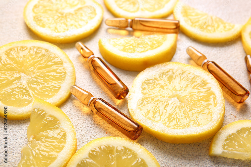 Ampoules with vitamin C and lemon slices on light background, closeup