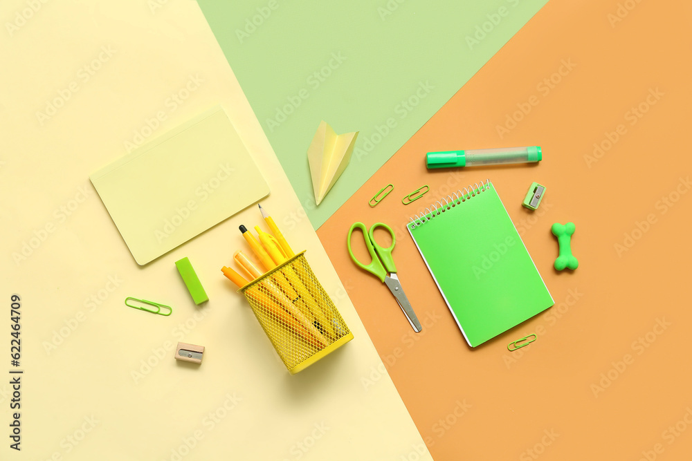 Composition with notebooks and different school stationery on color background