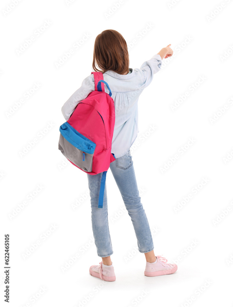 Little girl with schoolbag pointing at something on white background, back view