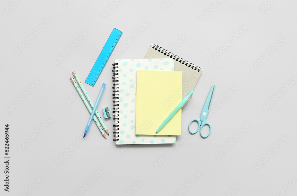 Notebooks and school stationery on grey background