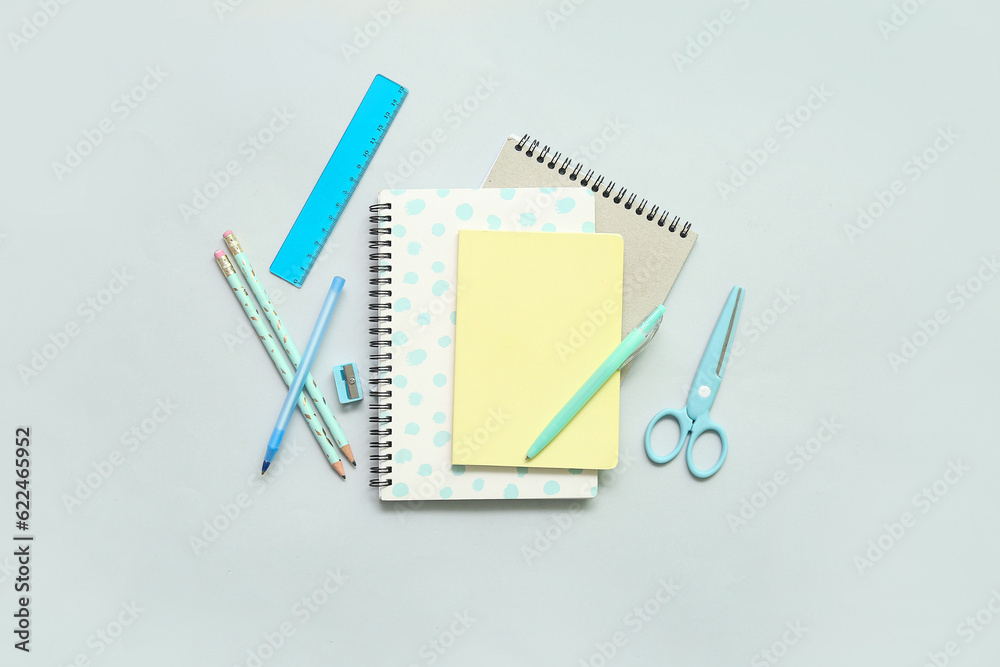 Notebooks and school stationery on grey background