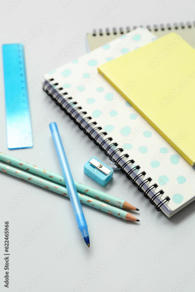 Notebooks and school stationery on grey background