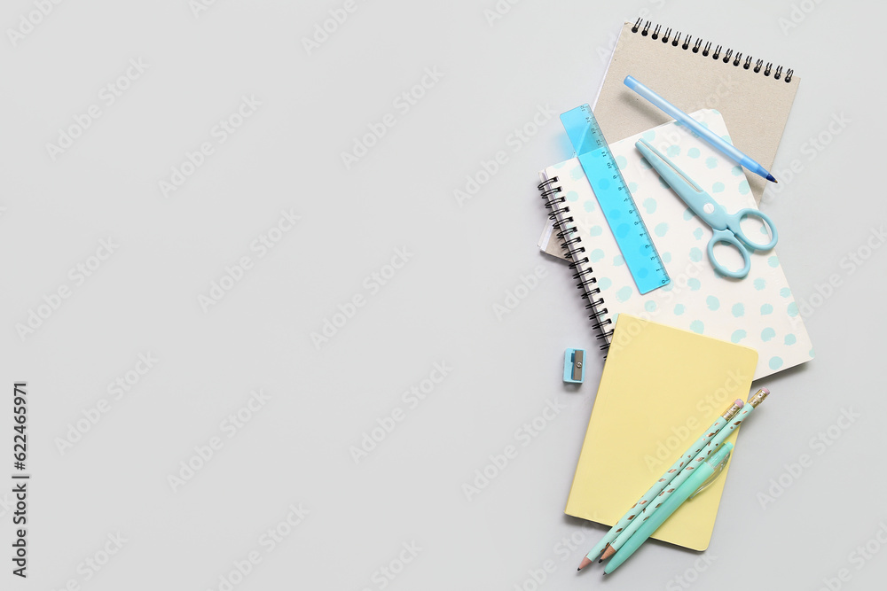 Notebooks and school stationery on grey background