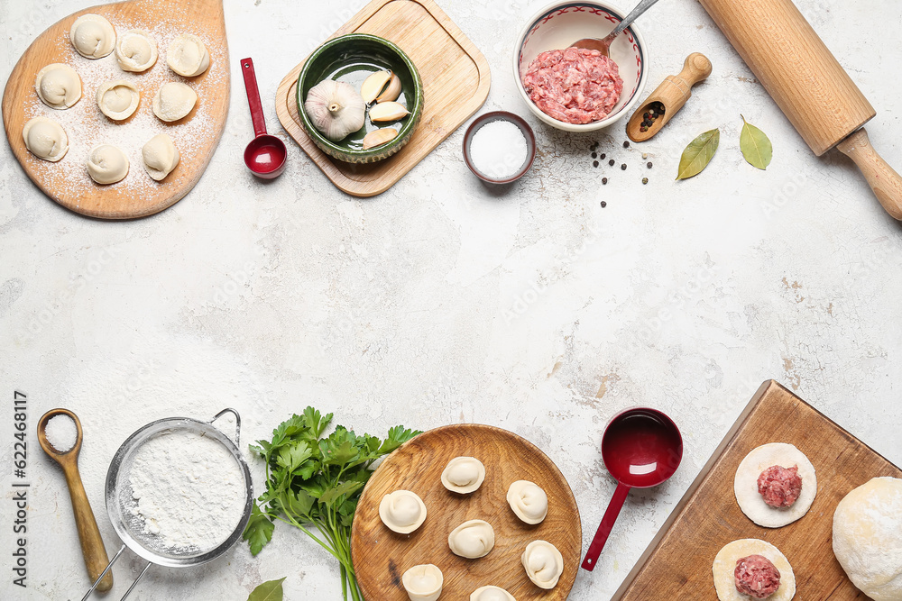 Uncooked dumplings and ingredients on light background