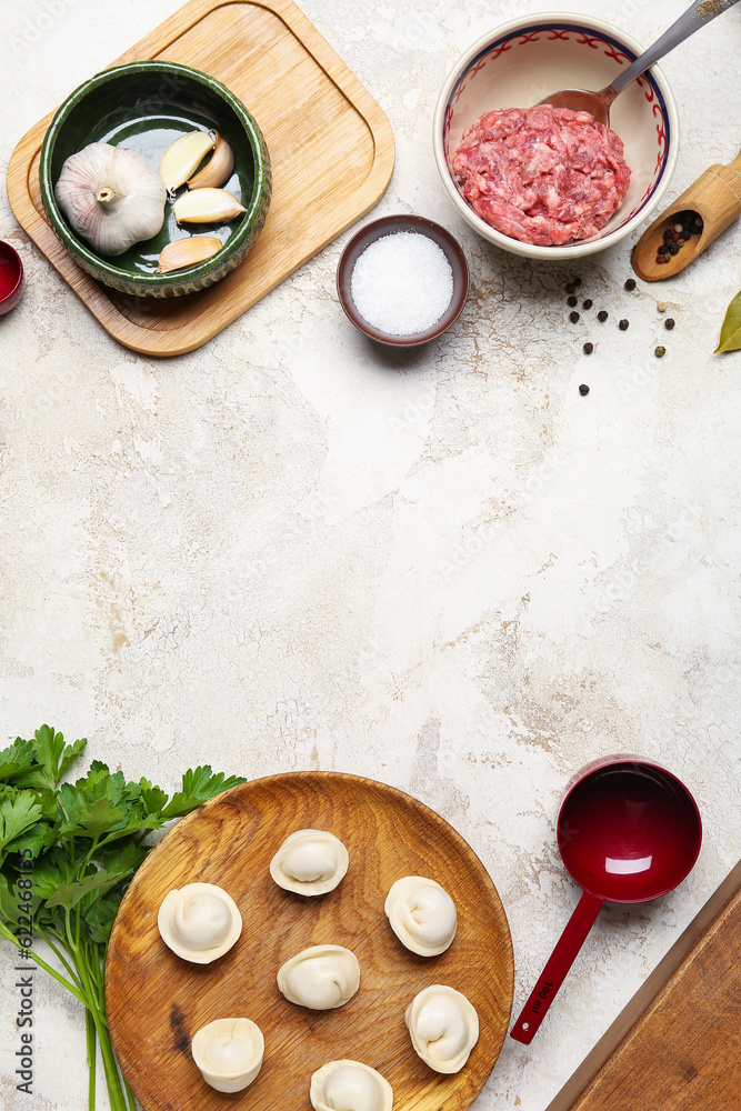 Plate with uncooked dumplings and ingredients on light background