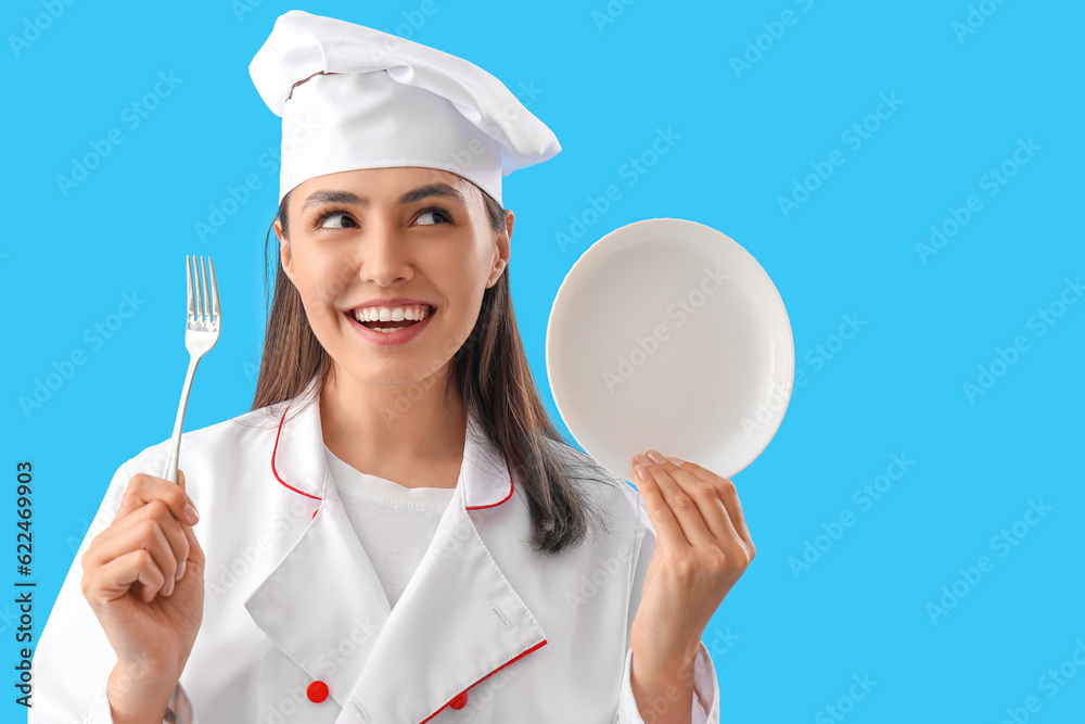 Female chef with fork and plate on blue background