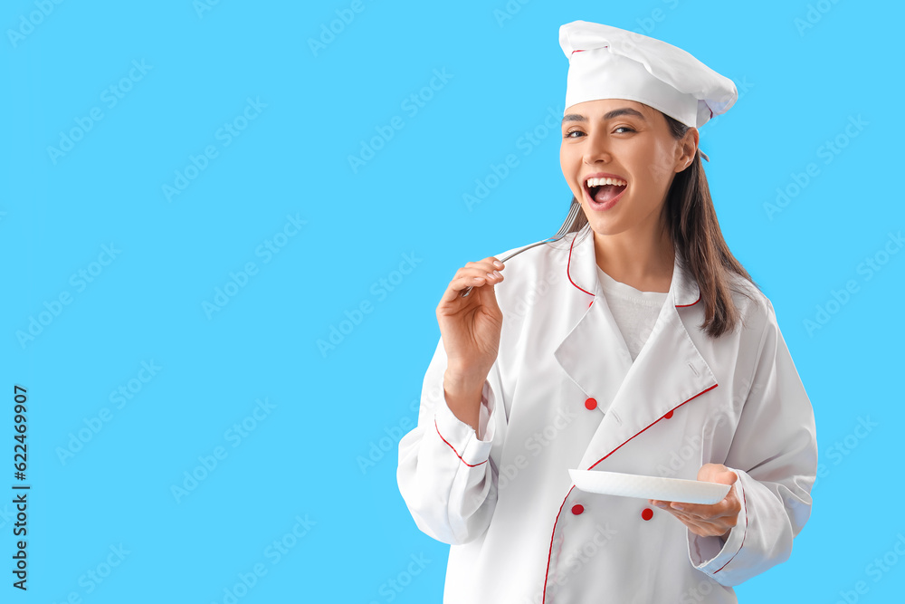 Female chef with fork and plate on blue background