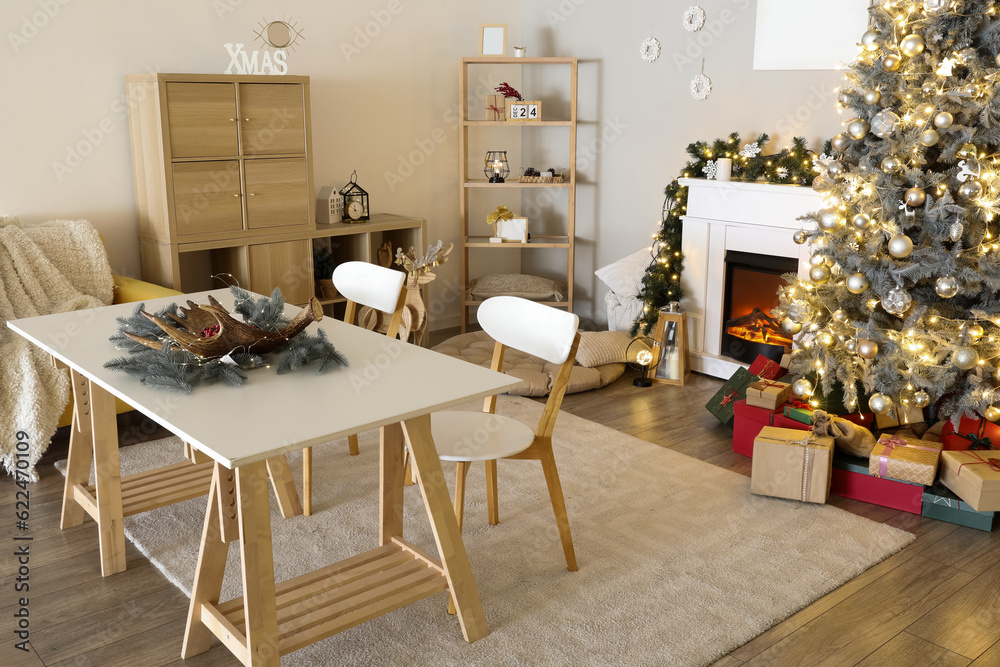 Interior of living room with dining table, Christmas tree and fireplace