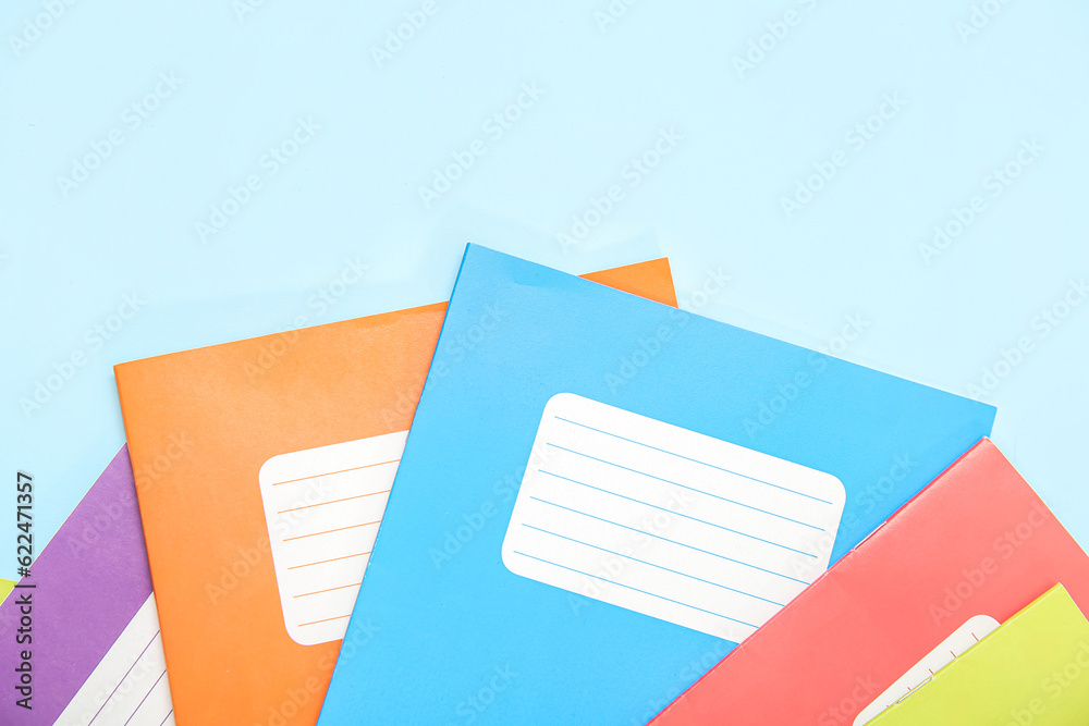 Different colorful notebooks on blue background