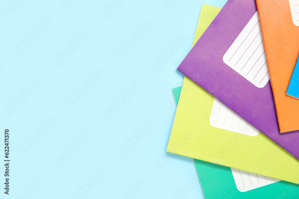 Different colorful notebooks on blue background