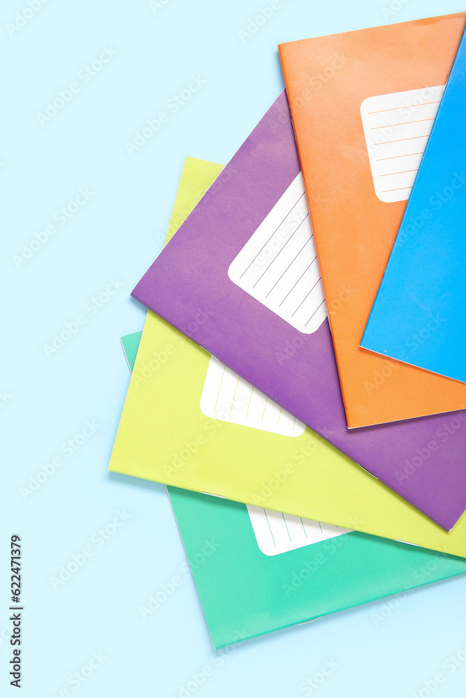 Different colorful notebooks on blue background