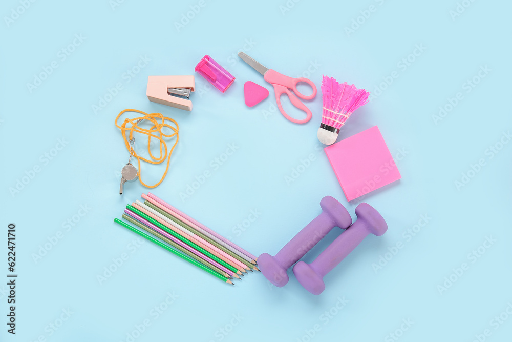 Frame made of sport equipment and different stationery on blue background