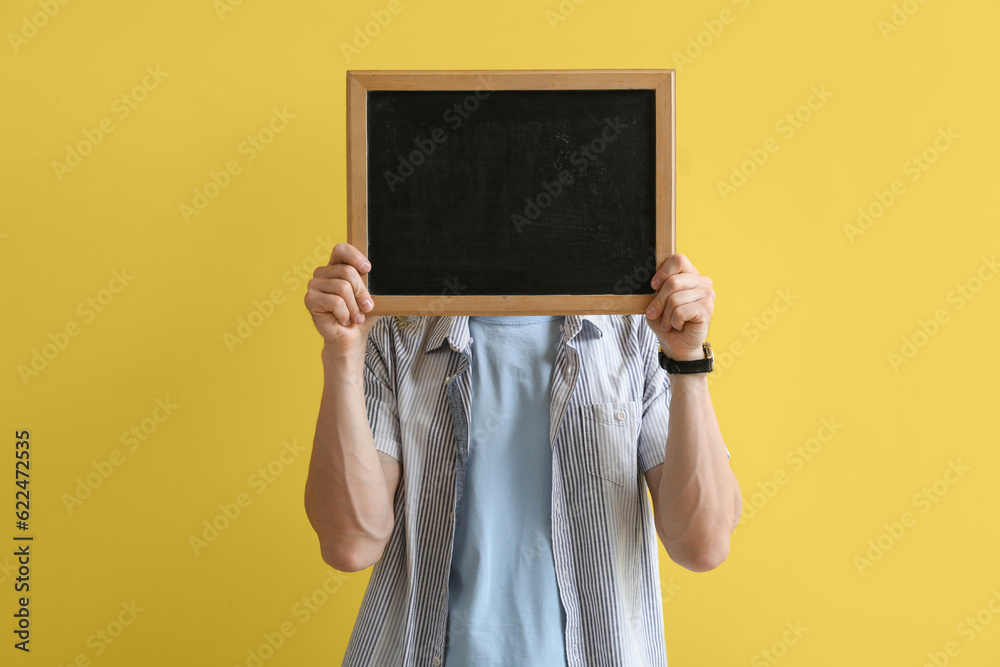 Male teacher with chalkboard on yellow background